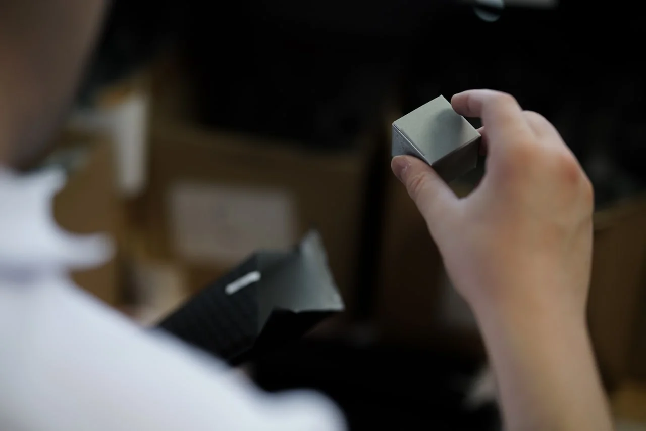 Close-up of a small product held by hand during handling.